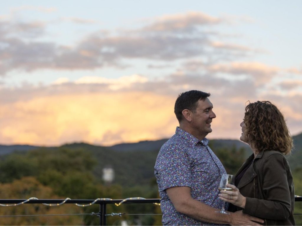 Couple enjoying drinks on the rooftop bar at the Schoolhouse Hotel in White Sulphur Springs, WV.